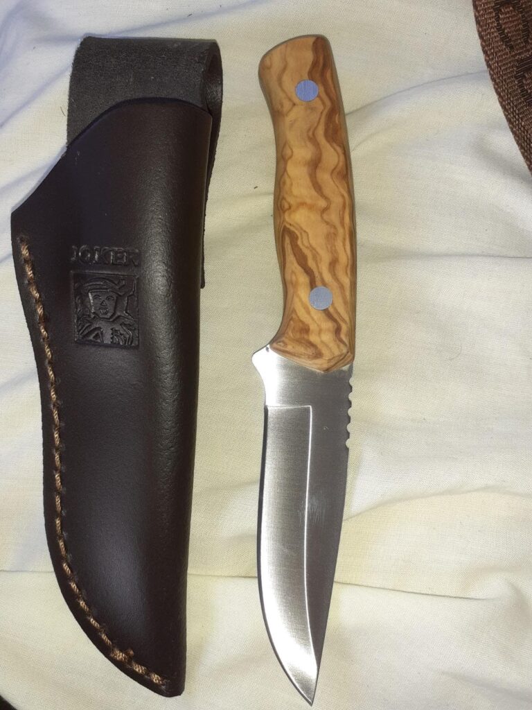 Cuchillo Yoker Bushcraft en una mesa para apreciar la funda de cuero y sus acabados.